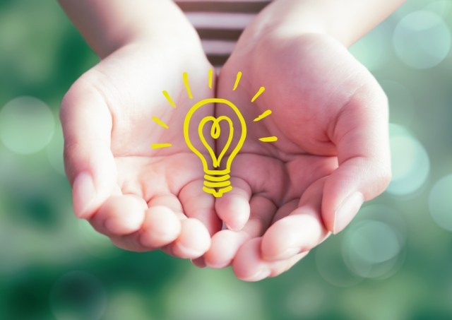 手のひらに乗せる電球のイラスト